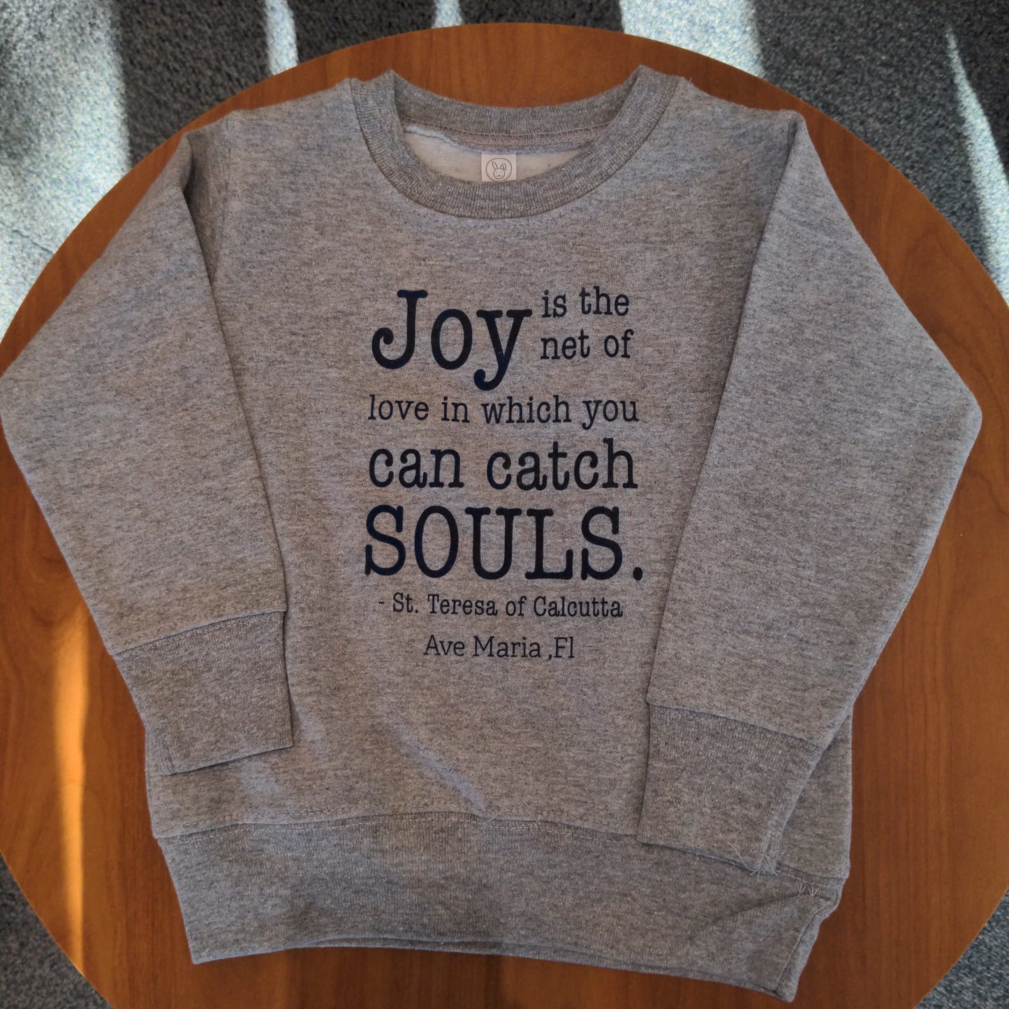 "Joy is the net of love in which you can catch souls" Youth Crewneck